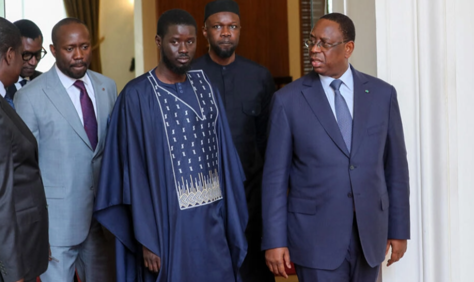 Image fournie par la présidence du Sénégal: l'opposant Ousmane Sonko (2e à dr.), le président Macky Sall (à dr.) et le président élu Bassirou Diomaye Faye (au centre) arpentent les couloirs du palais présidentiel, à Dakar, le 28 mars 2024. AFP - -